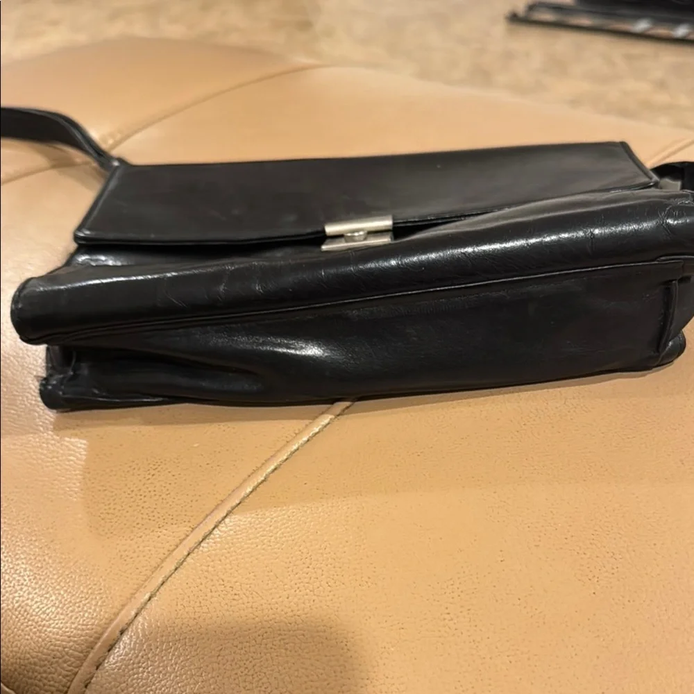 Black Messenger Bag with Sleek Design and Metallic Hardware